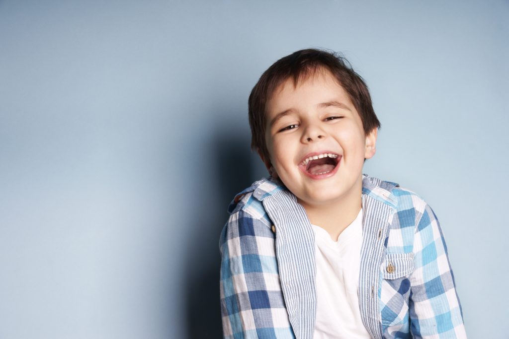 Laughing child in blue checkered shirt.