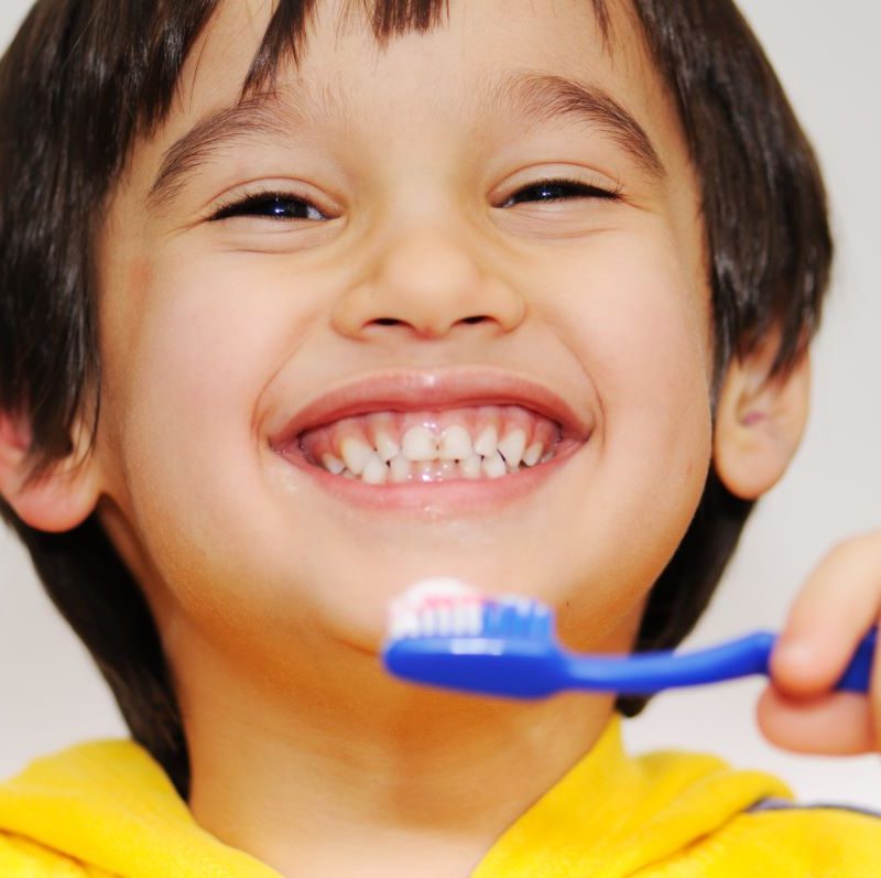 Boy smiling while practicing good oral health.